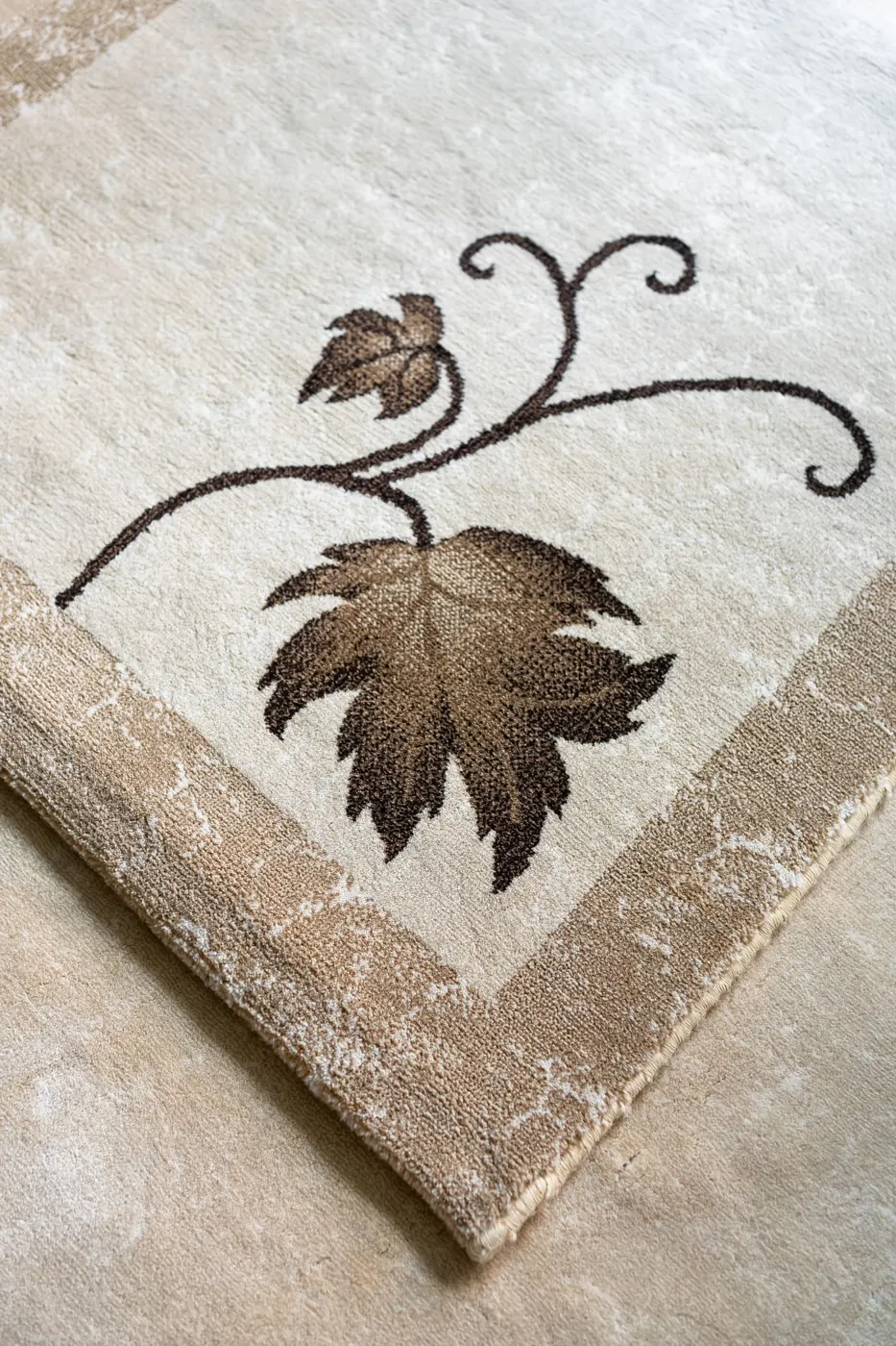 Close-up of a beige wool rug with a carved leaf pattern
